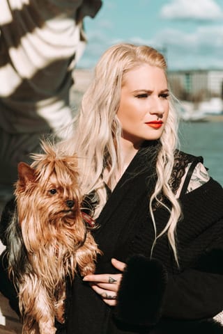 Frau mit einem kleinen Hund im Freien