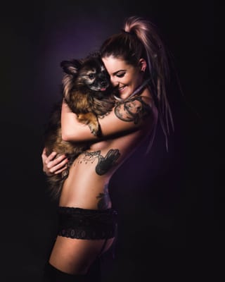 Frau mit einem kleinen Hund in dunklem Studio
