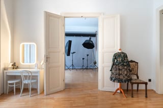 Ein aufgeräumte Fotostudio mit hoher Decke und Hintergrund in Ferne.